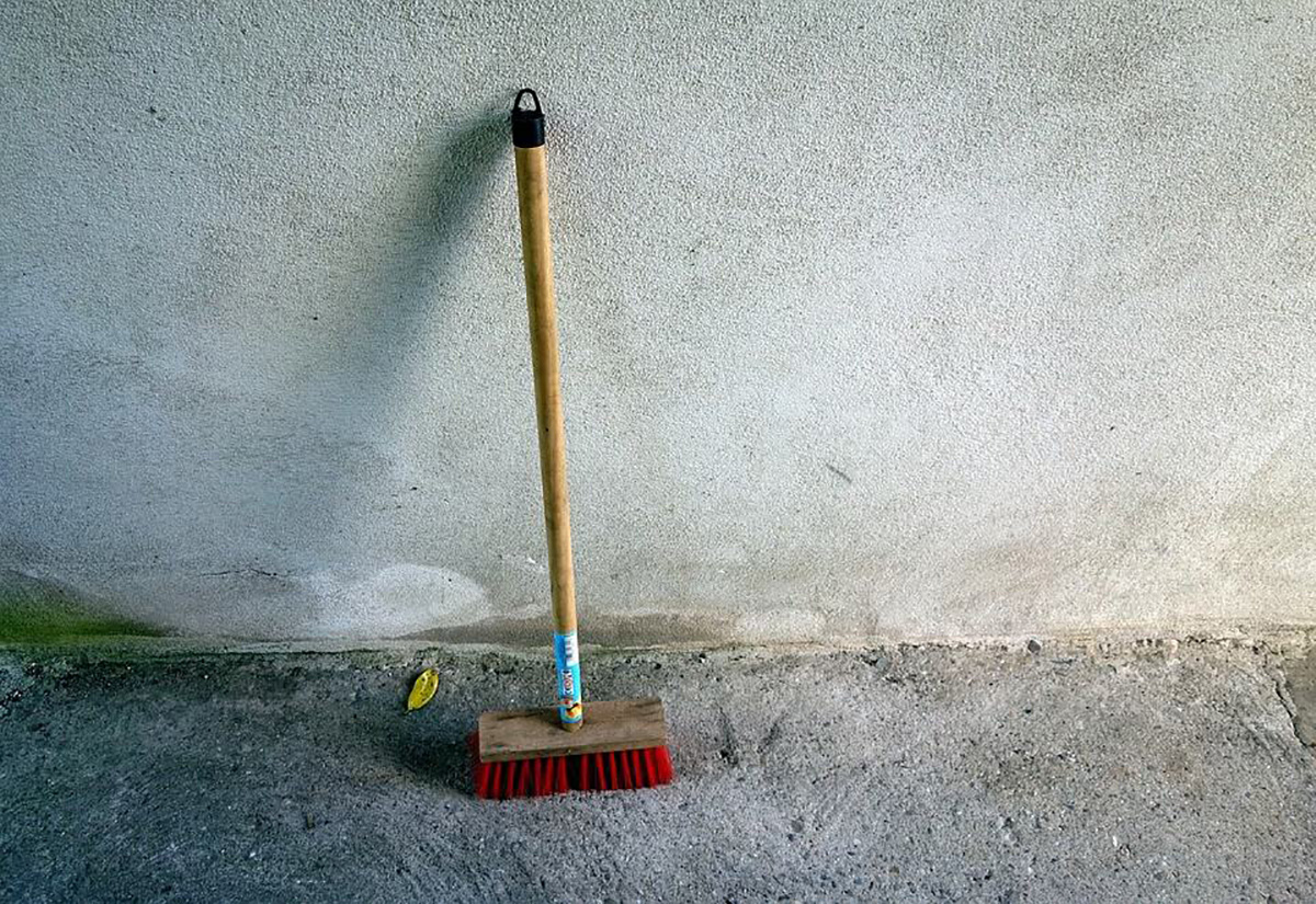 Un balai contre un mur.