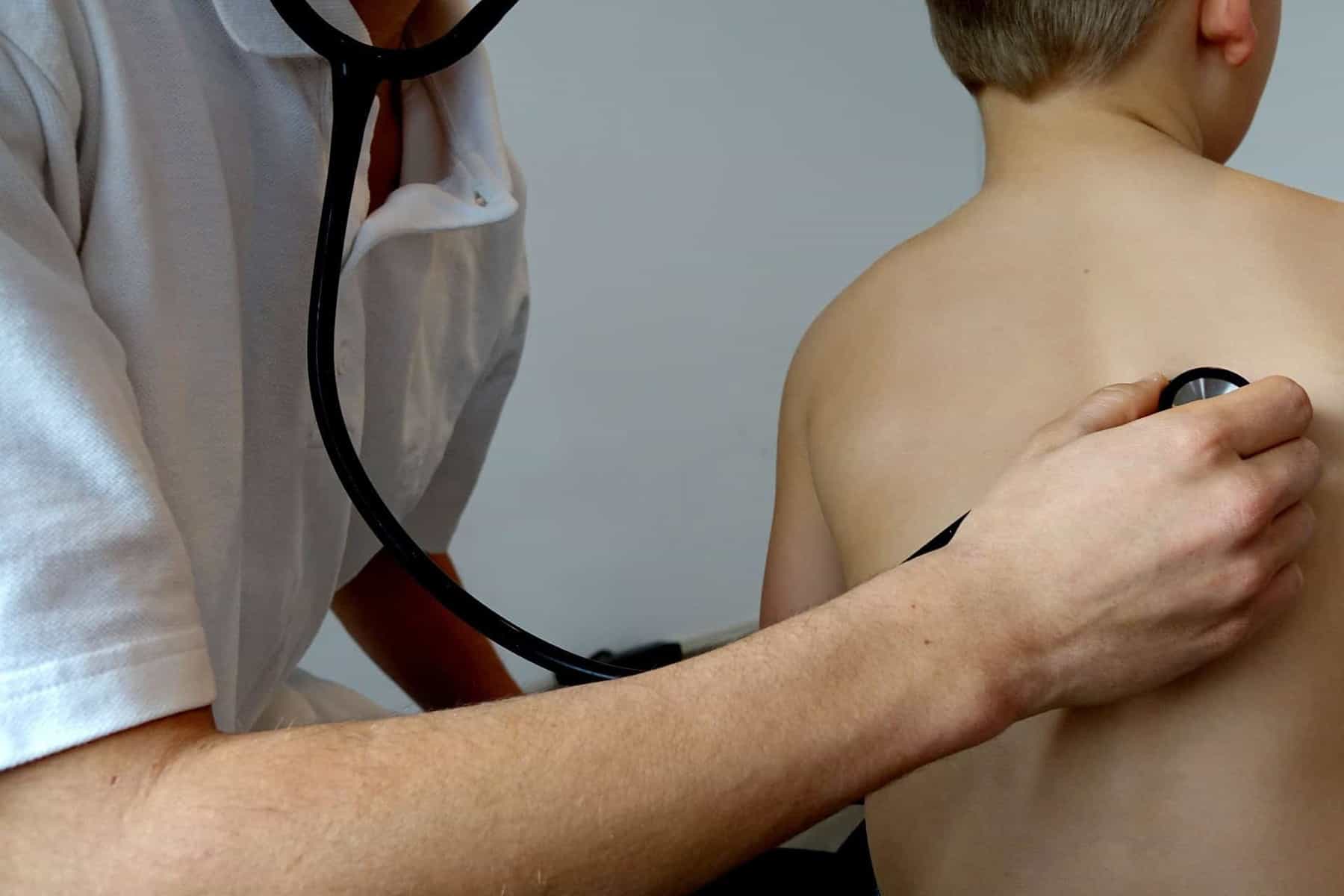 Illustration. Un docteur auscultant un enfant.